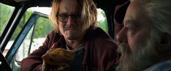 Movie still from “Secret Window” (2004), directed by David Koepp – A man with a beard and glasses eating a hot dog; Close Up shot, Low angle