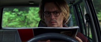 Movie still from “Secret Window” (2004), directed by David Koepp – A person sitting in a car reading a book; Close Up shot, Over the shoulder angle