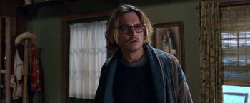 Movie still from “Secret Window” (2004), directed by David Koepp – A man with long blonde hair wearing glasses and a scarf; Close Up shot, Over the shoulder angle