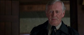 Movie still from “Secret Window” (2004), directed by David Koepp – An older man in a police uniform looking at the camera; Close Up shot, Over the shoulder angle