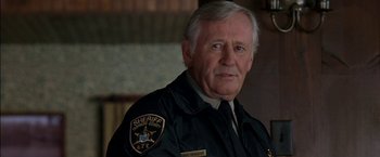 Movie still from “Secret Window” (2004), directed by David Koepp – An older man wearing a sheriff's uniform; Close Up shot, Over the shoulder angle