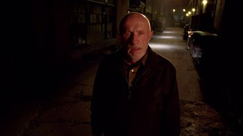 Movie still from “Breaking Bad” (2008), created by Vince Gilligan – An older man standing in the dark on the street; Medium shot, Low angle