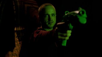Movie still from “Breaking Bad” (2008), created by Vince Gilligan – A man holding a gun in a dark room at night; Close Up shot, Over the shoulder angle