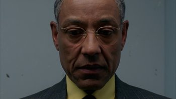Movie still from “Breaking Bad” (2008), created by Vince Gilligan – An older man wearing glasses and a suit; Close Up shot, Low angle