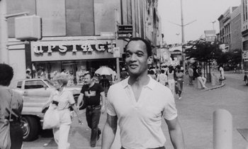 Movie still from “She's Gotta Have It” (1986), directed by Spike Lee – A black and white photo of a man walking down the street; Medium shot, Low angle