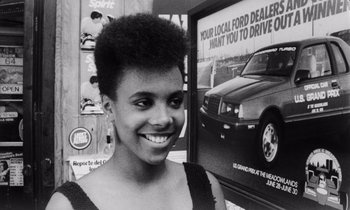 Movie still from “She's Gotta Have It” (1986), directed by Spike Lee – A black and white photo of a woman smiling for the camera; Close Up shot, Low angle