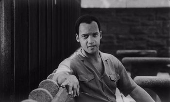 Movie still from “She's Gotta Have It” (1986), directed by Spike Lee – A black and white photo of a man holding a skateboard; Close Up shot, Low angle