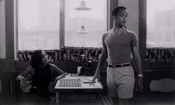 Movie still from “She's Gotta Have It” (1986), directed by Spike Lee – A black and white photo of a man and a woman in a room; Medium shot, Low angle