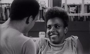 Movie still from “She's Gotta Have It” (1986), directed by Spike Lee – A woman and a boy are smiling at each other; Close Up shot, Over the shoulder angle