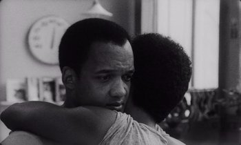Movie still from “She's Gotta Have It” (1986), directed by Spike Lee – A man and a woman hugging each other in black and white; Close Up shot, Over the shoulder angle