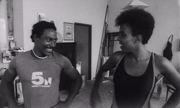 Movie still from “She's Gotta Have It” (1986), directed by Spike Lee – A man and a woman are talking in a living room; Medium shot, Low angle