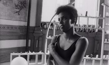 Movie still from “She's Gotta Have It” (1986), directed by Spike Lee – A black and white photo of a woman holding a hula hoop; Close Up shot, Low angle