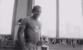 Movie still from “She's Gotta Have It” (1986), directed by Spike Lee – Black and white photograph of a man in gym clothes; Medium shot, Low angle