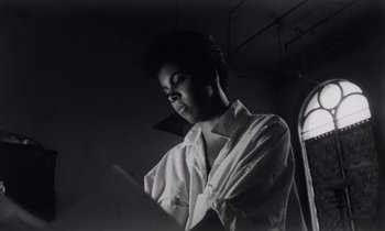 Movie still from “She's Gotta Have It” (1986), directed by Spike Lee – A black and white photo of a person holding a phone; Close Up shot, Low angle