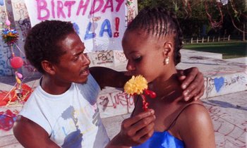 Movie still from “She's Gotta Have It” (1986), directed by Spike Lee – A man and a woman holding a yellow flower; Medium shot, Low angle