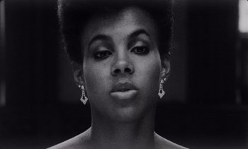 Movie still from “She's Gotta Have It” (1986), directed by Spike Lee – A black and white photo of a woman's face; Close Up shot, Low angle