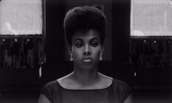 Movie still from “She's Gotta Have It” (1986), directed by Spike Lee – A black and white photo of a woman with a large afro; Close Up shot, Low angle