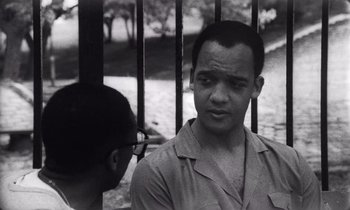 Movie still from “She's Gotta Have It” (1986), directed by Spike Lee – A black - and - white photo of a man talking to another man; Close Up shot, Low angle