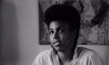 Movie still from “She's Gotta Have It” (1986), directed by Spike Lee – A black and white photo of a woman looking at the camera; Close Up shot, Low angle