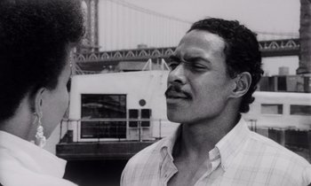 Movie still from “She's Gotta Have It” (1986), directed by Spike Lee – A black and white photo of a man with a mustache; Close Up shot, Low angle
