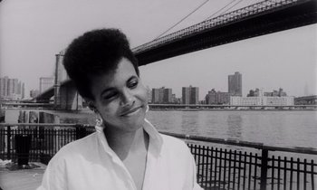 Movie still from “She's Gotta Have It” (1986), directed by Spike Lee – A black and white photo of a woman in front of a river; Close Up shot, Low angle