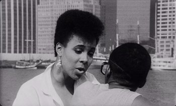 Movie still from “She's Gotta Have It” (1986), directed by Spike Lee – A black and white photo of a woman talking to another woman; Close Up shot, Over the shoulder angle