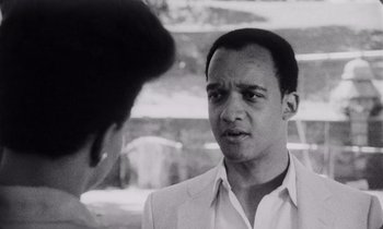 Movie still from “She's Gotta Have It” (1986), directed by Spike Lee – A black and white photo of a man talking to another man; Close Up shot, Over the shoulder angle