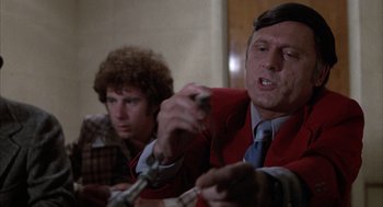 Movie still from “Slap Shot” (1977), directed by George Roy Hill – Two men sitting at a dinner table holding forks; Close Up shot, Low angle
