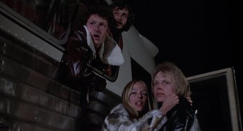 Movie still from “Slap Shot” (1977), directed by George Roy Hill – A group of people standing on some stairs; Medium shot, Low angle