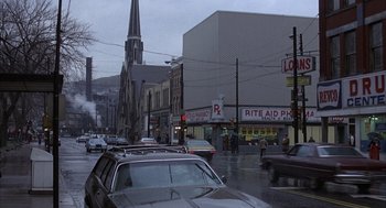 Movie still from “Slap Shot” (1977), directed by George Roy Hill – A street scene with cars parked on the side of the road; Extreme Wide shot, High angle
