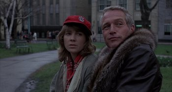 Movie still from “Slap Shot” (1977), directed by George Roy Hill – A man and a woman standing next to each other; Close Up shot, Low angle