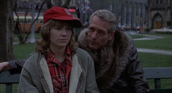 Movie still from “Slap Shot” (1977), directed by George Roy Hill – A man and a woman standing next to each other on the street; Close Up shot, Over the shoulder angle