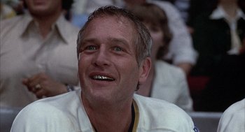 Movie still from “Slap Shot” (1977), directed by George Roy Hill – A person with a smile on his face; Close Up shot, Low angle