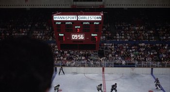 Movie still from “Slap Shot” (1977), directed by George Roy Hill – A crowd of people watching a hockey game in progress; Extreme Wide shot, High angle