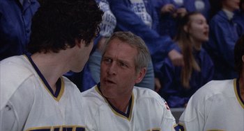 Movie still from “Slap Shot” (1977), directed by George Roy Hill – A hockey player talking to another player in the stands; Close Up shot, Over the shoulder angle
