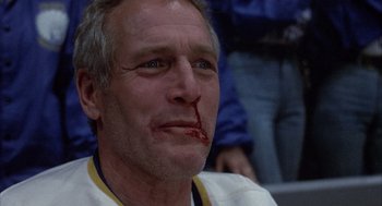 Movie still from “Slap Shot” (1977), directed by George Roy Hill – A person with blood on his face; Close Up shot, Low angle