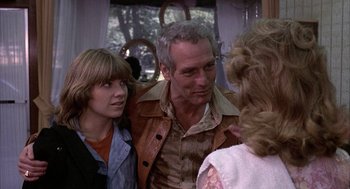 Movie still from “Slap Shot” (1977), directed by George Roy Hill – A man and two women talking to each other on a bus; Medium shot, Over the shoulder angle