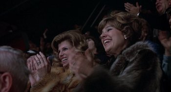Movie still from “Slap Shot” (1977), directed by George Roy Hill – A couple of women sitting next to each other in a room; Close Up shot, High angle