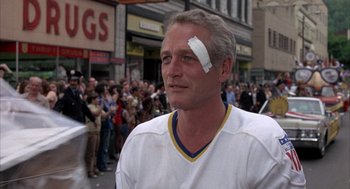Movie still from “Slap Shot” (1977), directed by George Roy Hill – A man with a bandage on his head; Close Up shot, Over the shoulder angle
