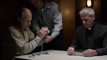 Movie still from “Slasher” (2016), created by Aaron Martin – Two men are chained to a table while another man watches; Medium shot, High angle