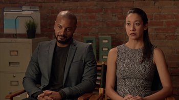 Movie still from “Slasher” (2016), created by Aaron Martin – A man and a woman sitting next to each other; Medium shot, Over the shoulder angle