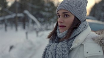 Movie still from “Slasher” (2016), created by Aaron Martin – A young woman wearing a hat and scarf in the snow; Close Up shot, Over the shoulder angle