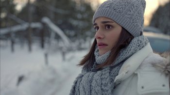 Movie still from “Slasher” (2016), created by Aaron Martin – A young woman wearing a hat and scarf in the snow; Close Up shot, Over the shoulder angle