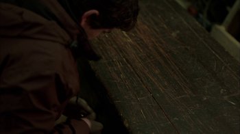 Movie still from “Slasher” (2016), created by Aaron Martin – A young boy looking down at a wooden floor; Medium shot, High angle
