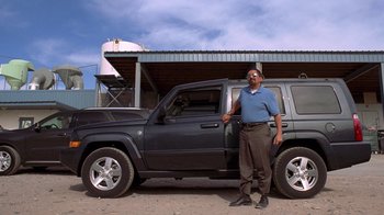 Movie still from “Breaking Bad” (2008), created by Vince Gilligan – A man standing in front of a black truck; Wide shot, Low angle