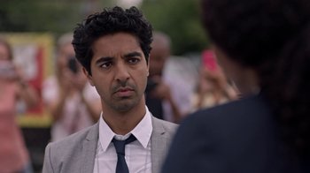 Movie still from “Slasher” (2016), created by Aaron Martin – A person wearing a suit and a tie; Close Up shot, Over the shoulder angle