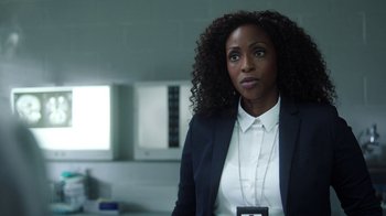 Movie still from “Slasher” (2016), created by Aaron Martin – A woman standing in a room; Close Up shot, Over the shoulder angle