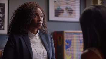 Movie still from “Slasher” (2016), created by Aaron Martin – A woman with curly hair wearing a jacket and a white shirt; Close Up shot, Over the shoulder angle