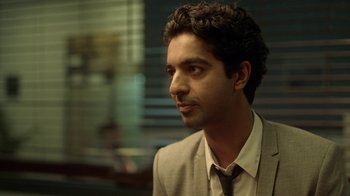 Movie still from “Slasher” (2016), created by Aaron Martin – A person wearing a suit and tie; Close Up shot, Over the shoulder angle