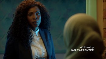 Movie still from “Slasher” (2016), created by Aaron Martin – A woman wearing a suit and tie talking to another woman; Close Up shot, Over the shoulder angle